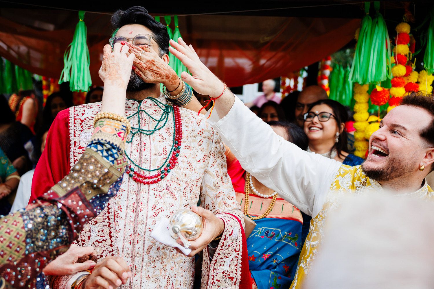 Indian wedding groom having his nose pinched