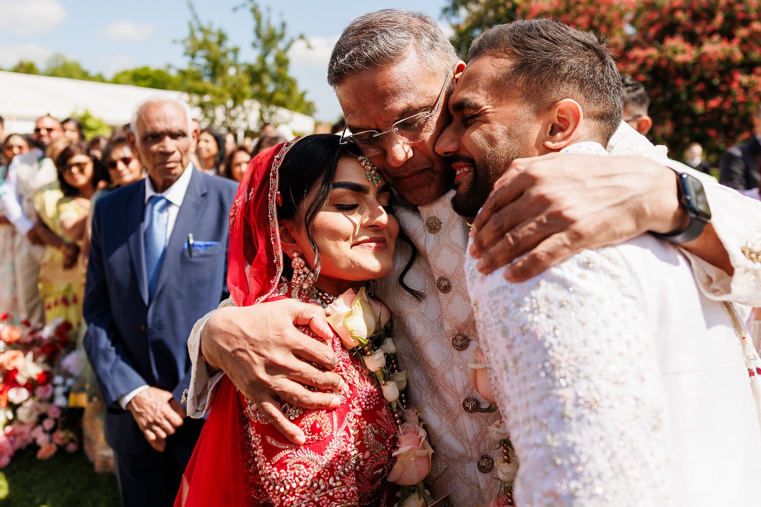 Bride and groom hugging dad