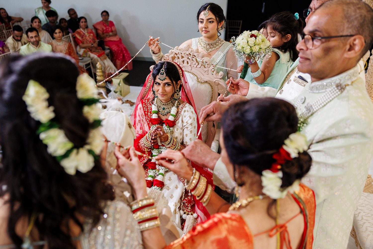 Bride smiling while her family gives their blessings