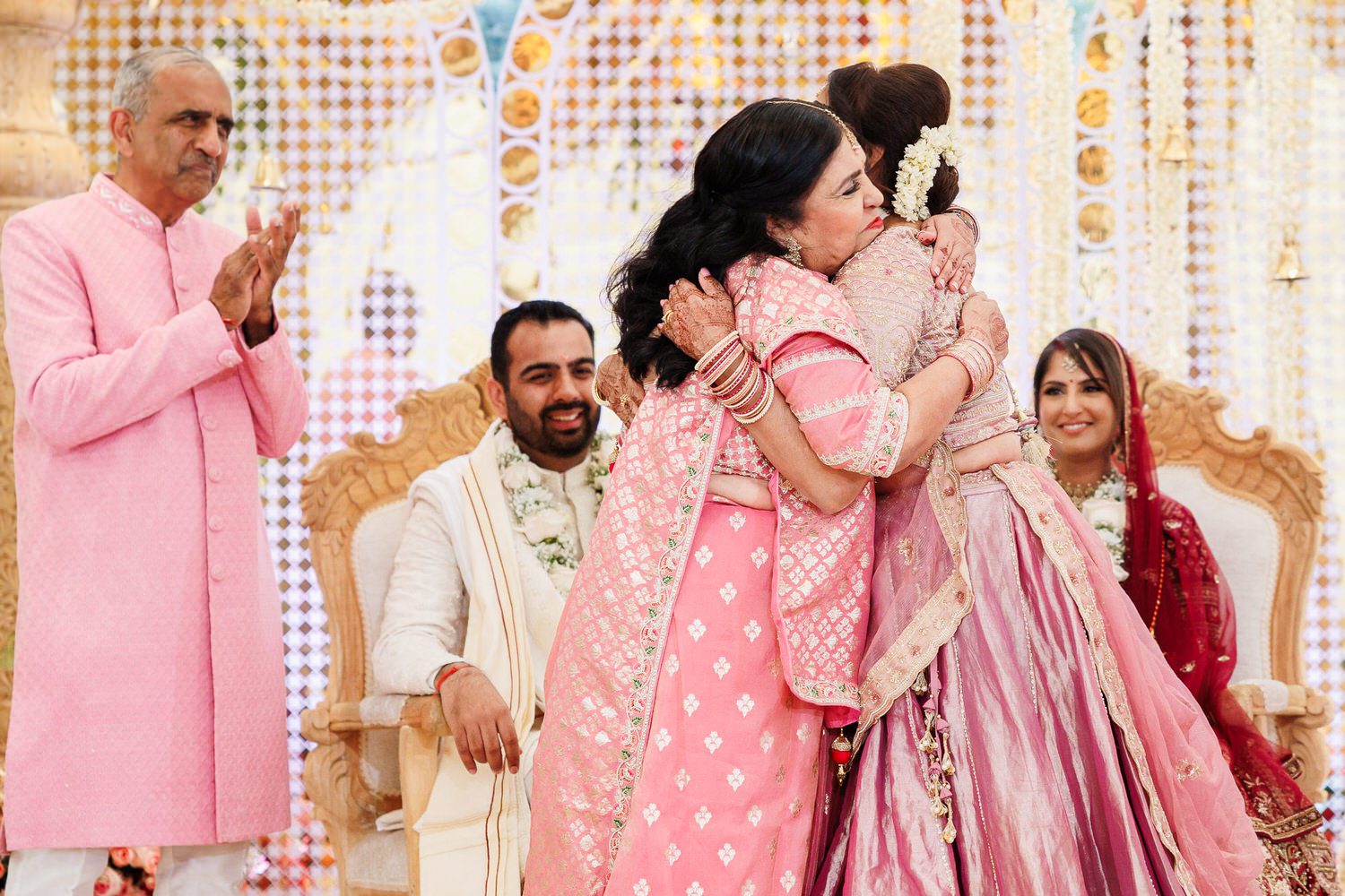 Parents of the wedding couple hugging