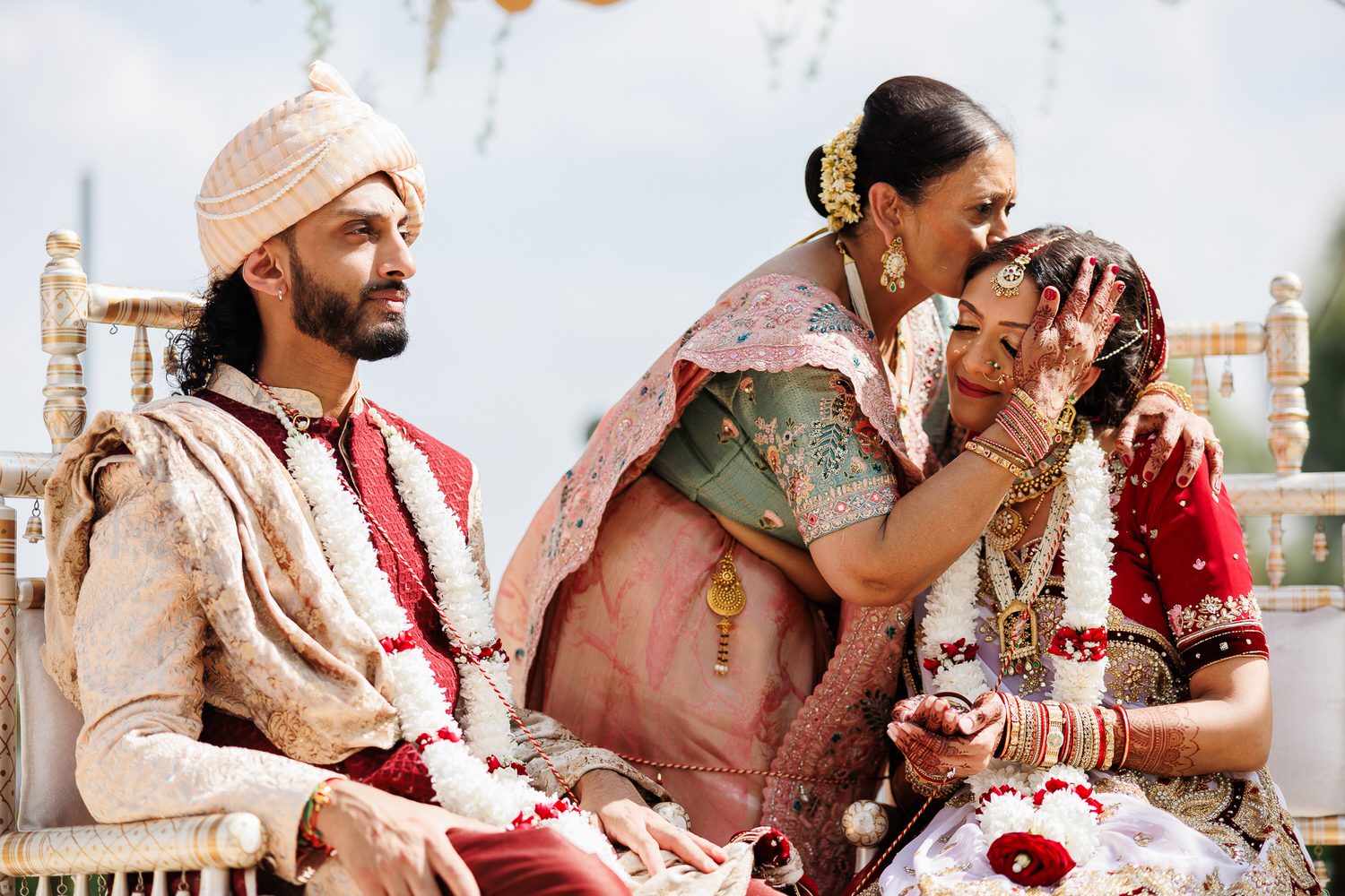 Bride being hugged and kissed by her mother