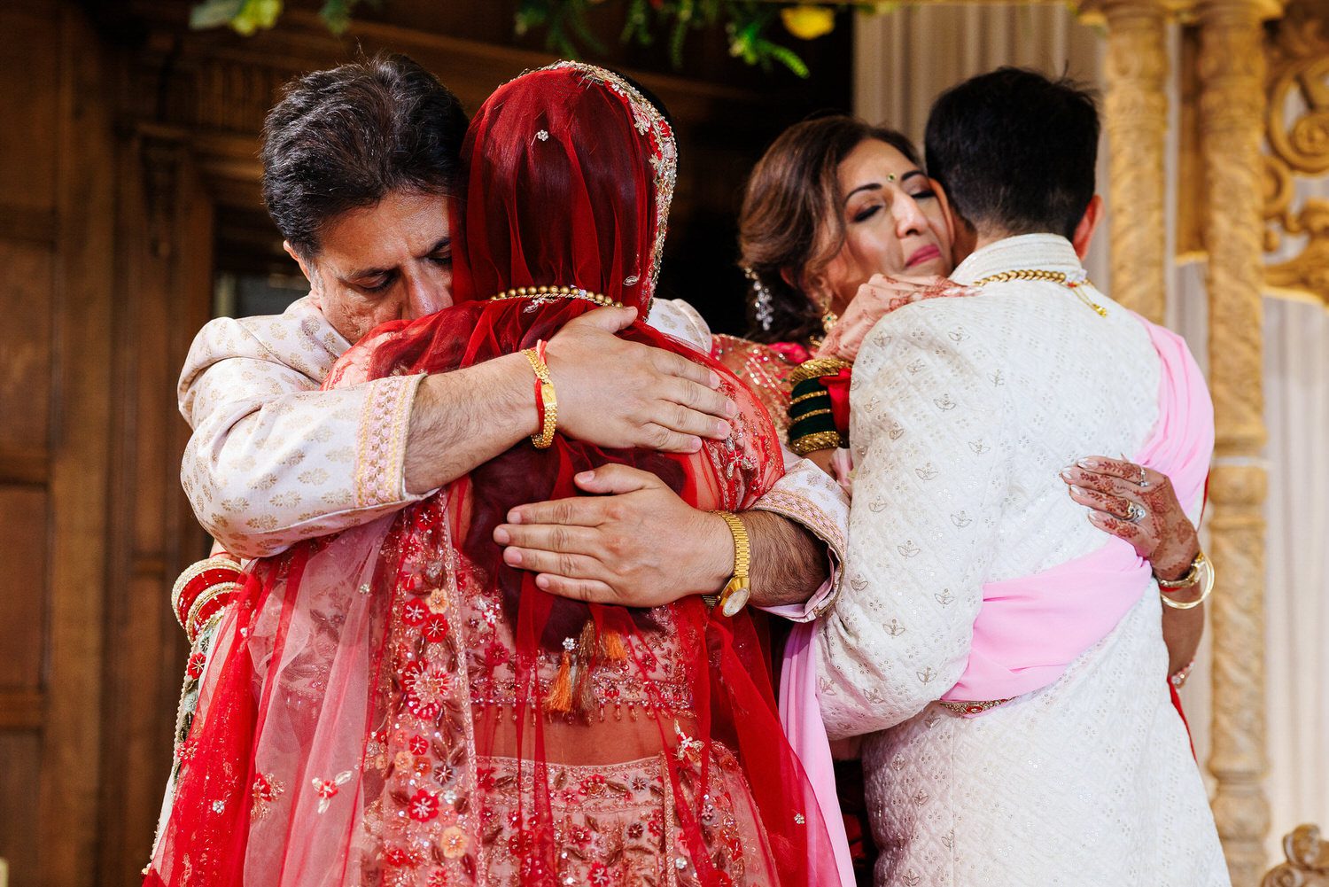 Parents hugging wedding couple