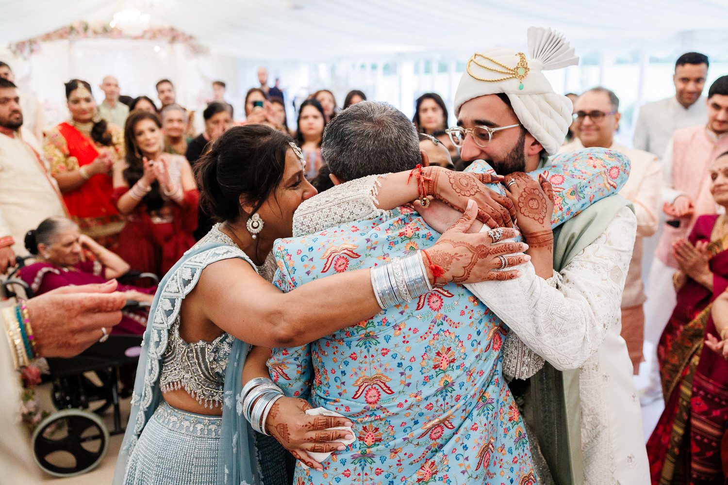 Parents hugging wedding couple
