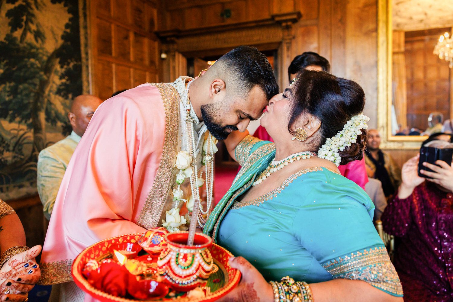 Mother of the bride kissing son in law on forehead