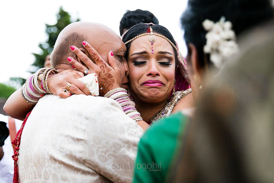 Bride hugging family members during vidhai ceremony