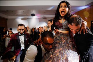 Bride and groom being lifted during repletion party