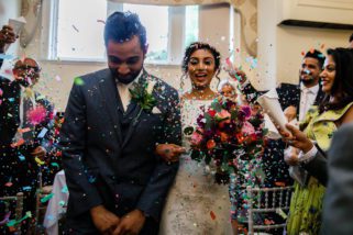 Bride and groom being showered with confetti