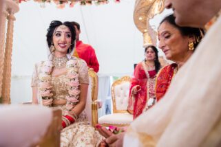 Hindu bride smiling at her mother during wedding ceremony