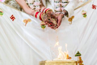 Bride and groom feeding the fire during mandap ceremony