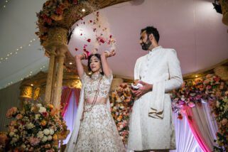 Bride throwing rice and rose petals behind her