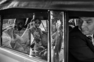 Bride waving goodbye in car