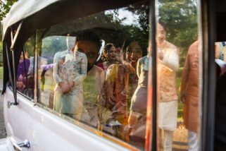 Bride waving goodbye in car