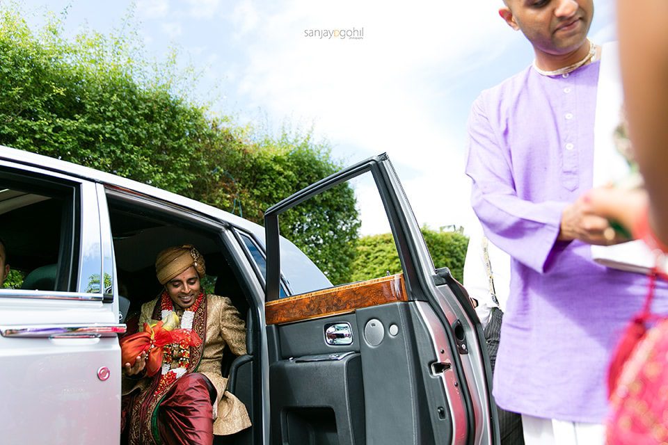 Hindu wedding groom getting out of the car