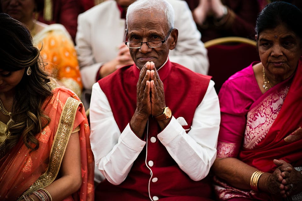 Asian Wedding guest praying