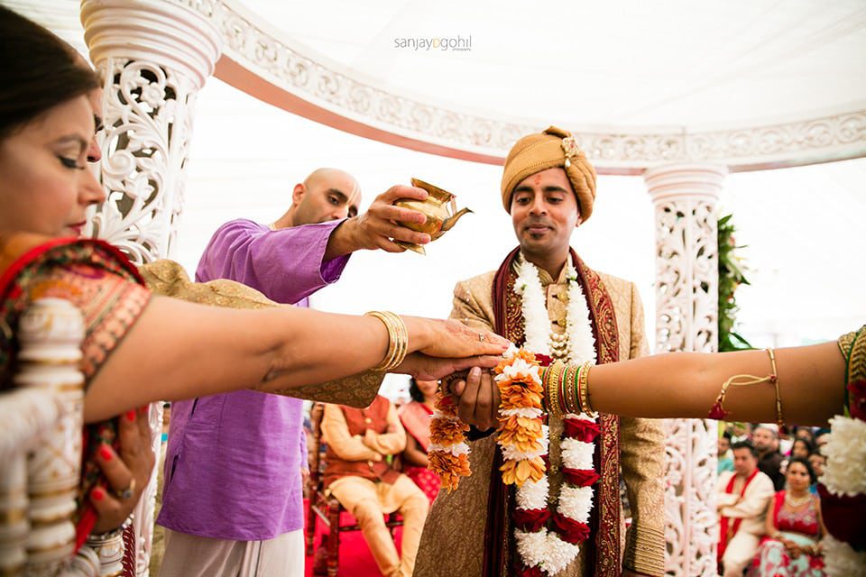 Water being poured to the hands of the bride and groom