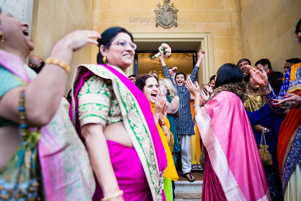 Bride's cousin with bouquet in the air 