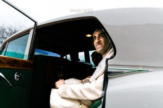 Asian wedding groom smiling in car