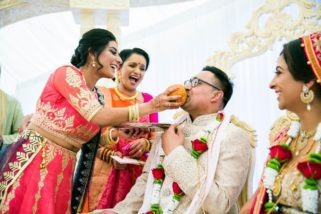 Groom being fed large Indian dish