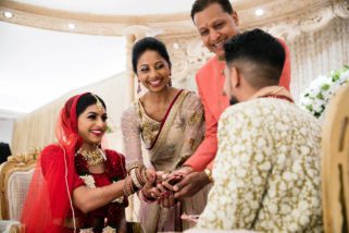 Bride's hands being placed on the palm of the groom's hands