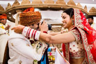 Groom taking photograph of bride