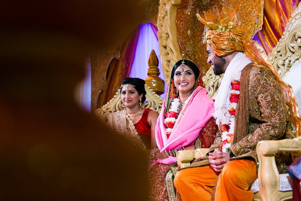Asian Wedding bride and groom laughing in the mandap 