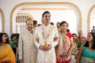 Hindu groom walking down the isle with bride's parents