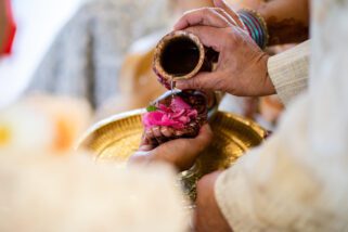 Water being poured on hands of bride and groom