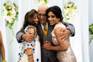 bride hugging family members at wedding
