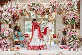 Hindu wedding garlanding ceremony under a wedding mandap