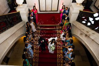 Bride and groom walking while being showered by confetti