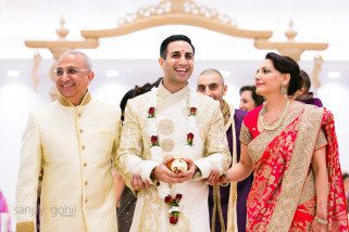 Groom walking and smiling with bride's parents
