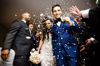 Confetti being poured onto bride and groom
