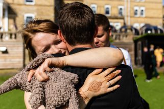 Family member hugging wedding groom