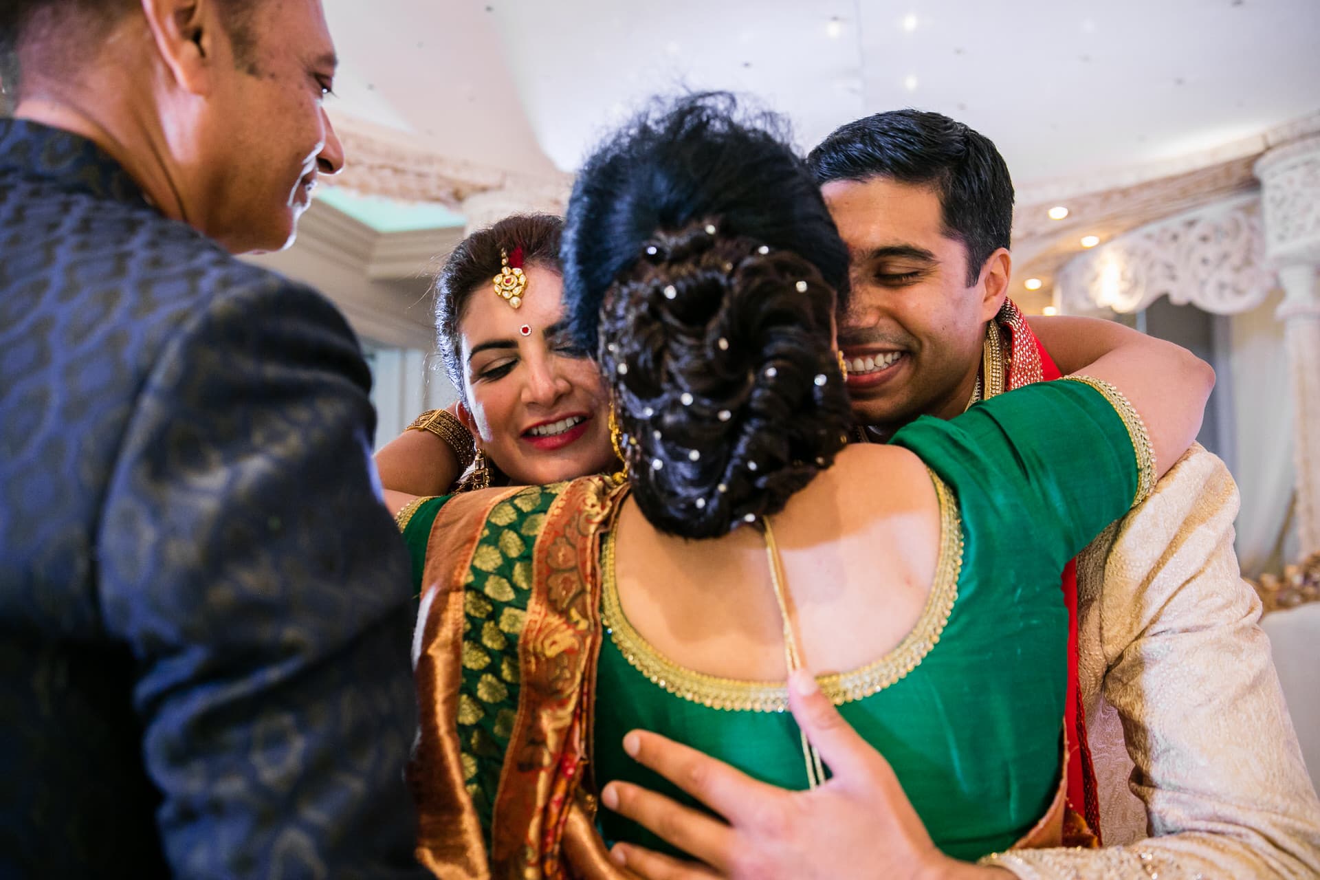 Wedding couple hugging parents