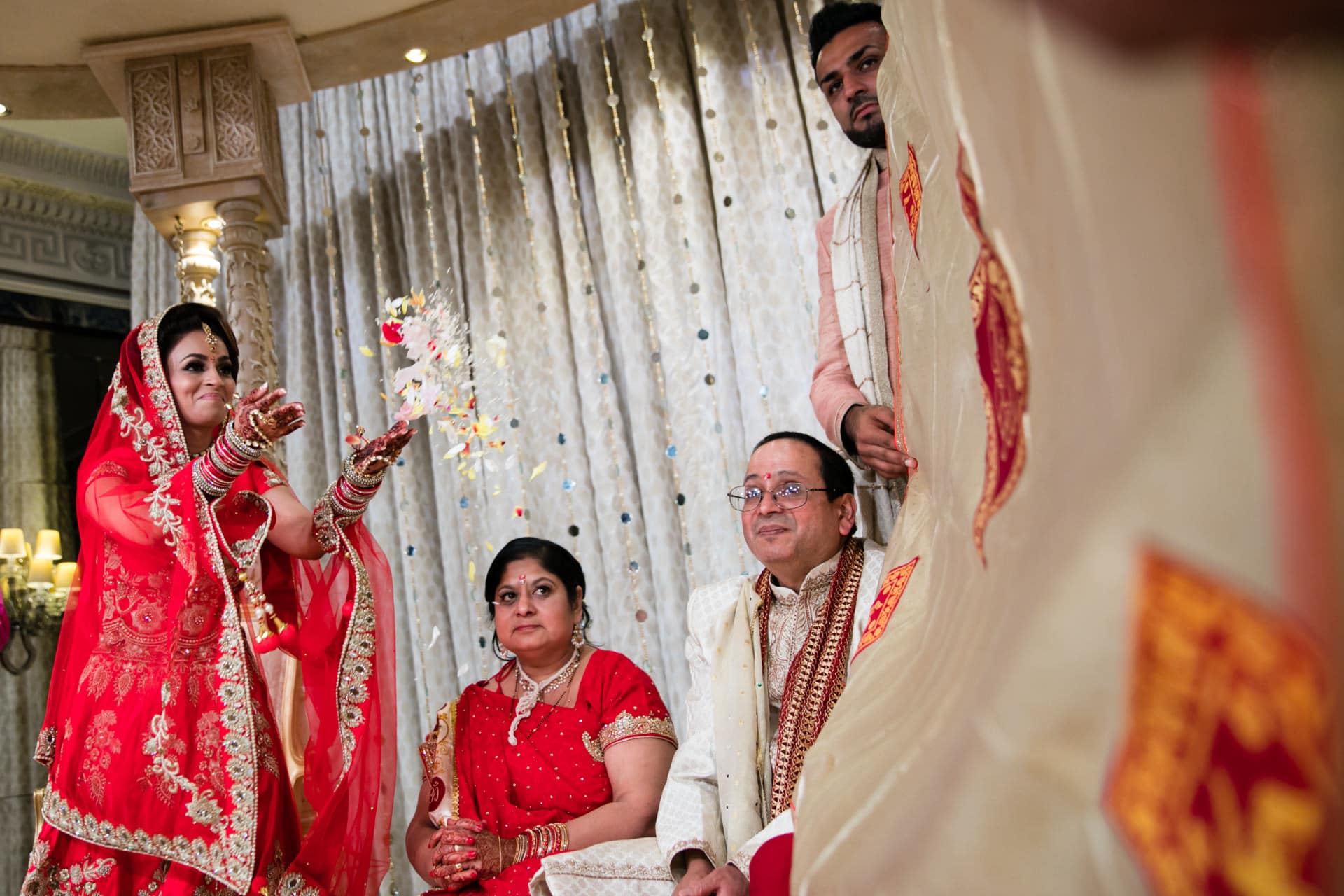 Bride throwing flowers towards the groom