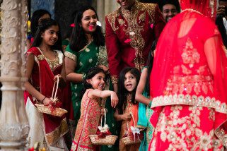 Wedding guests throwing flowers to the bride and groom