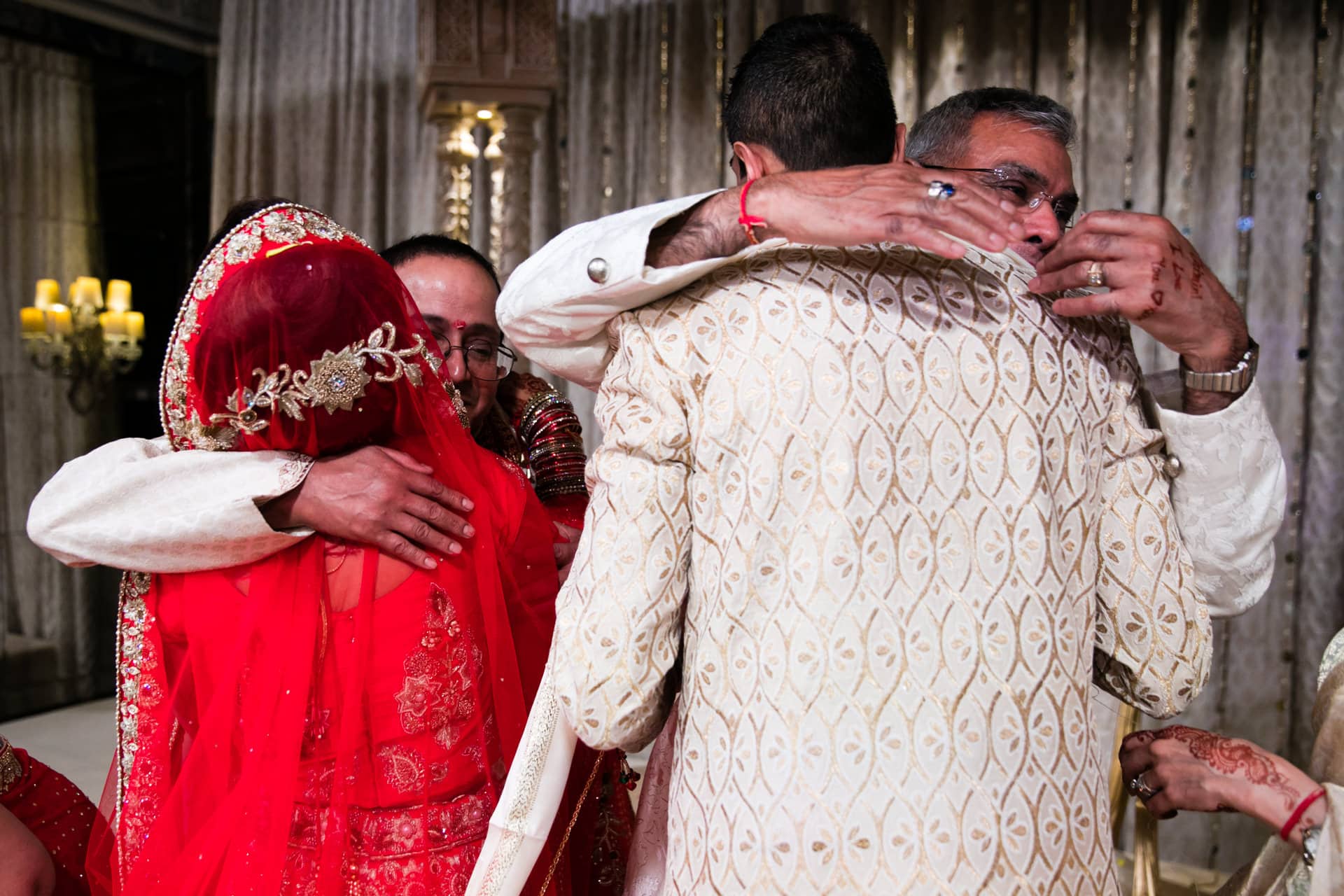 Bride and groom hugging parents