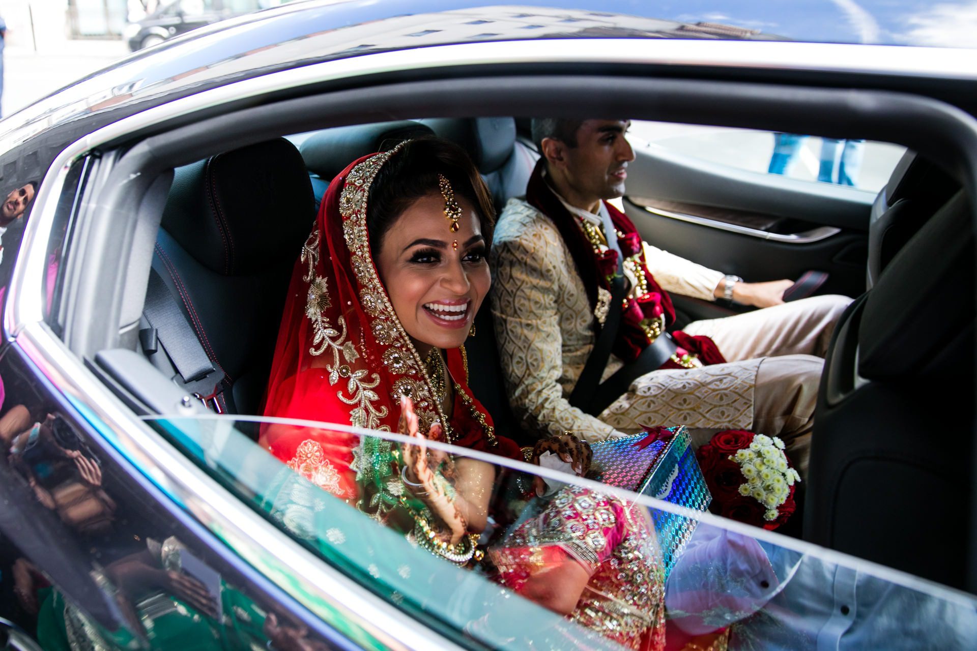 Asian Bride waving goodbye before the car leaves