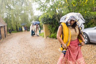 Asian wedding guests arriving for wedding in the rain