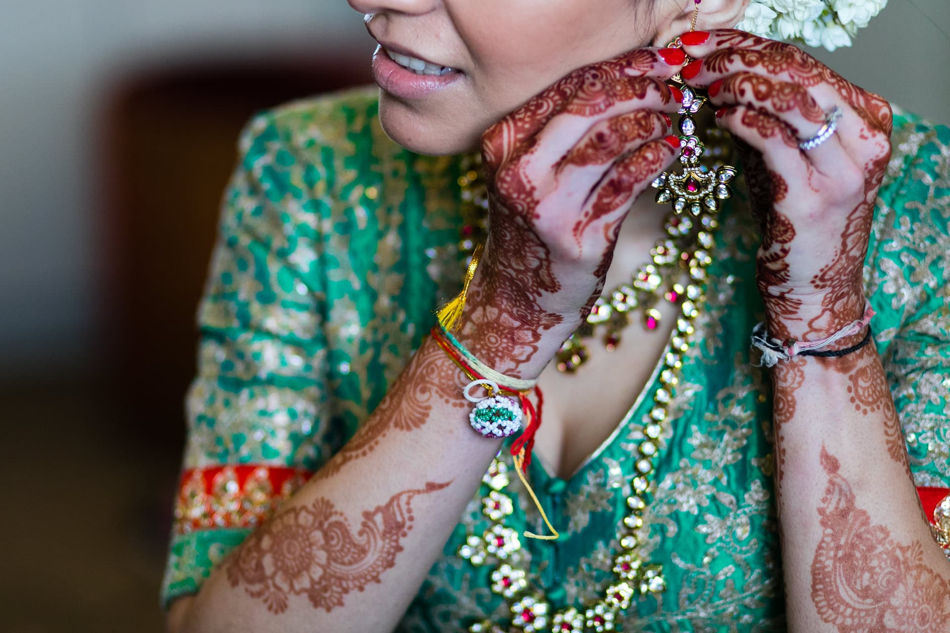 Asian bride putting earrings on