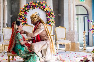 Groom putting Mangal Sutra onto bride