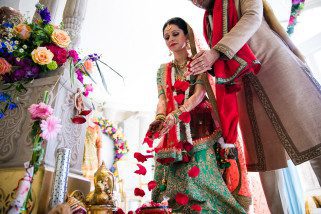 Wedding couple offering rose petals to Ganeshji