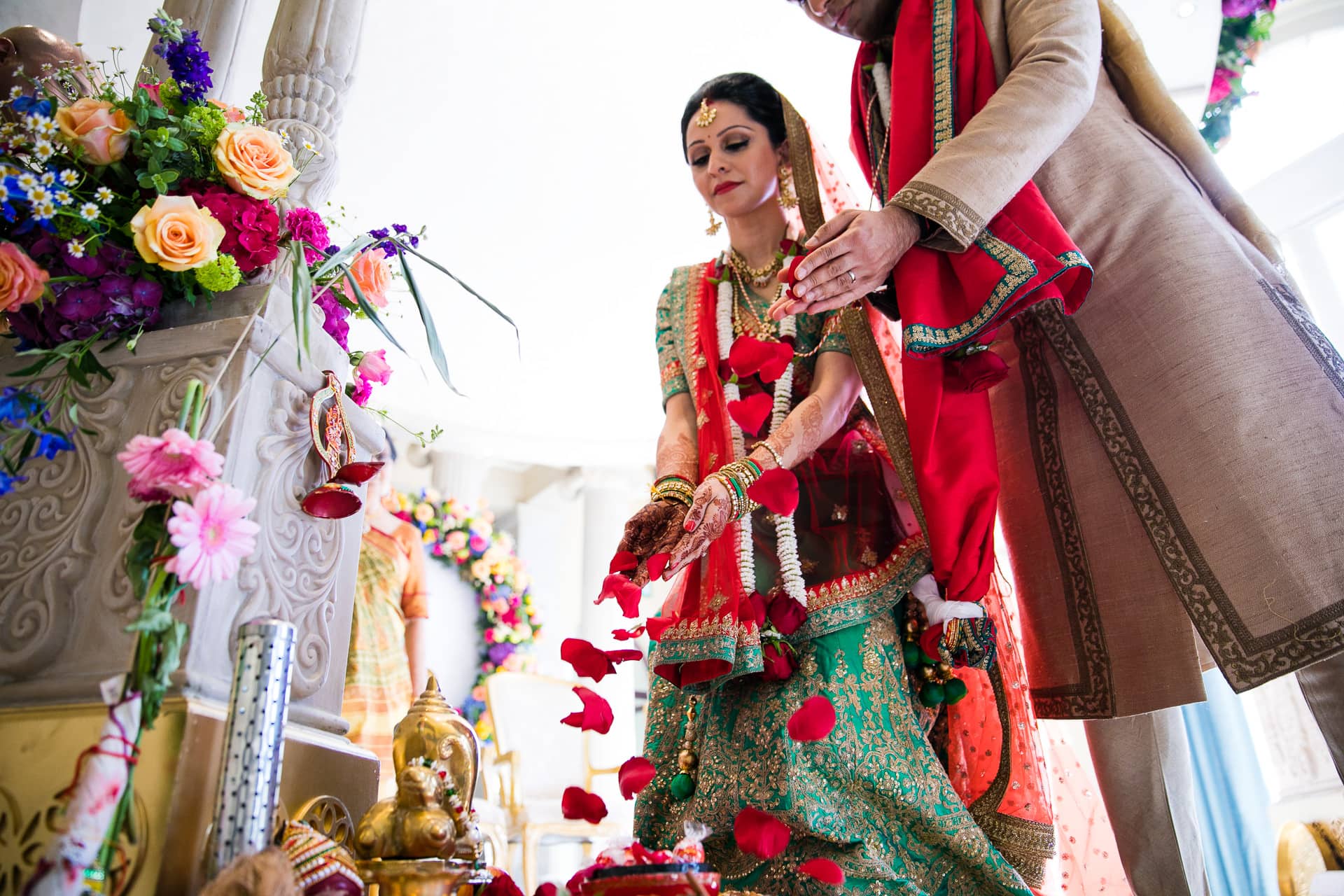 Wedding couple offering rose petals to Ganeshji