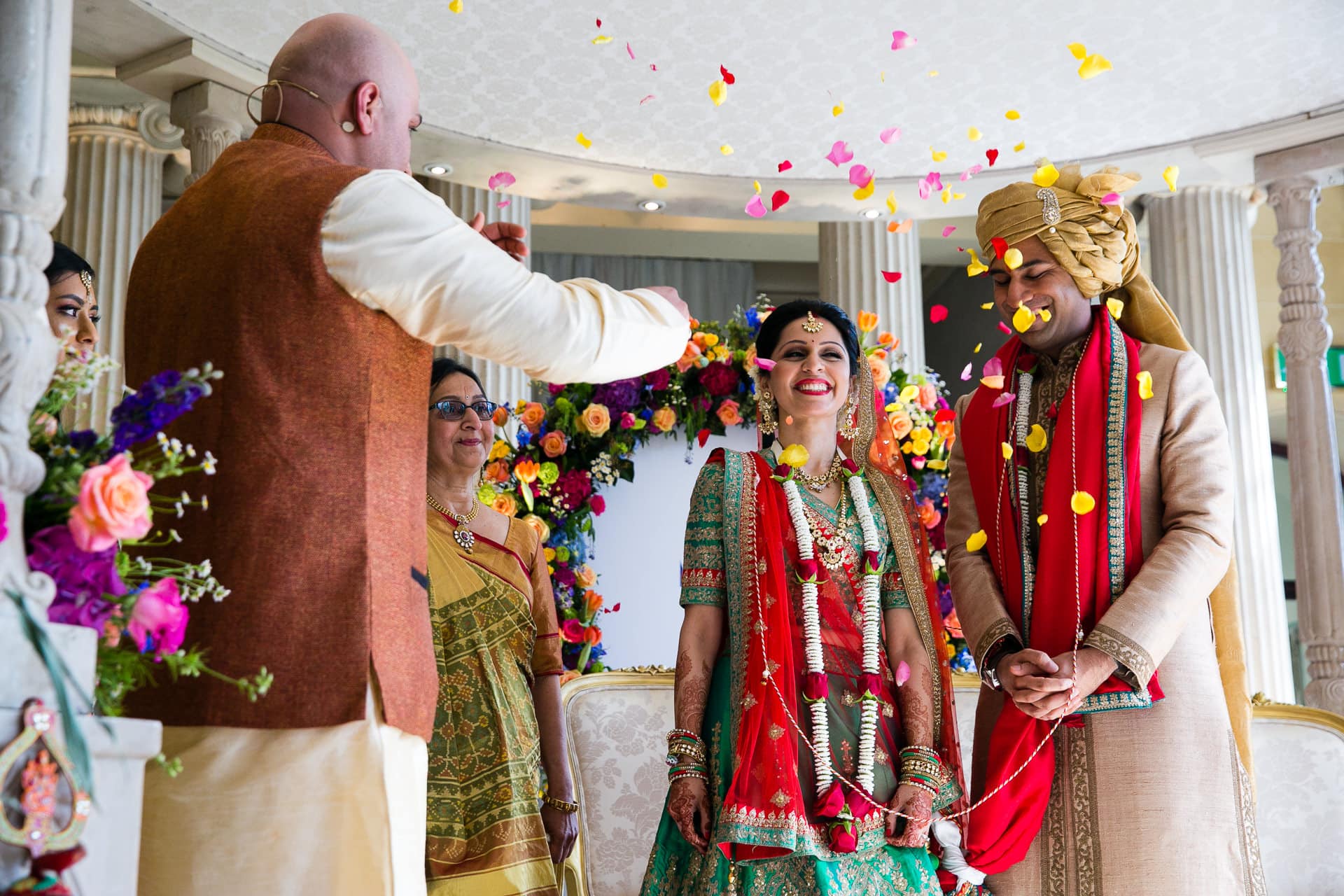 Bride and groom being showered with flowers by Pandit Paarth Joshi