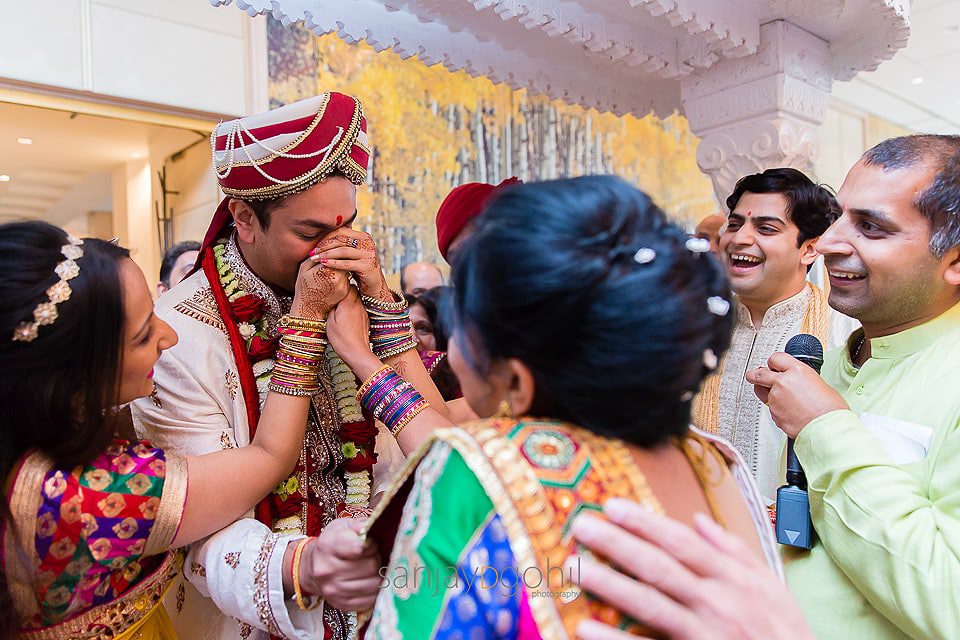 Asian Wedding groom having his nose pinched