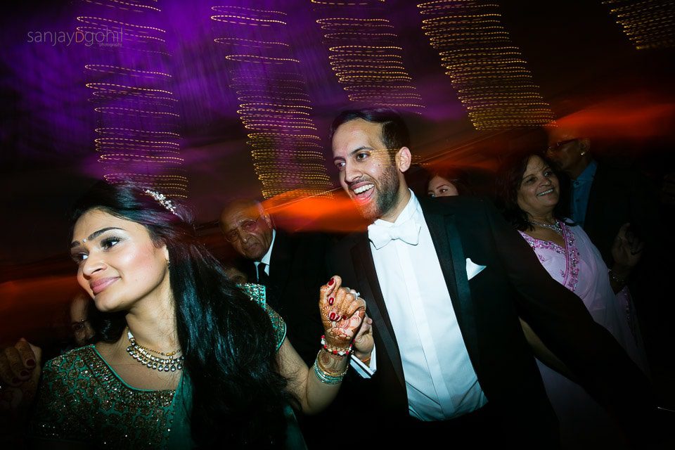 Asian wedding guests dancing during reception party at Saville Court