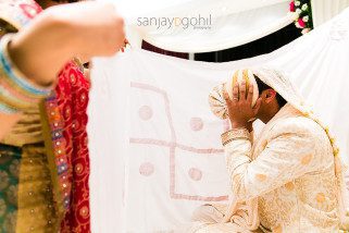Asian Wedding groom covering his face