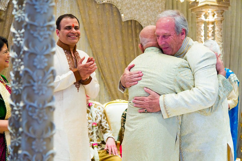 Fathers of the bride and groom hugging