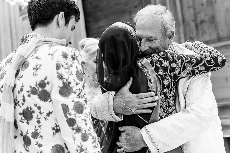 Father of groom hugging bride