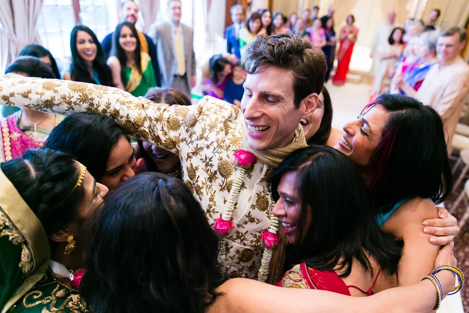 Bride and groom hugging friends